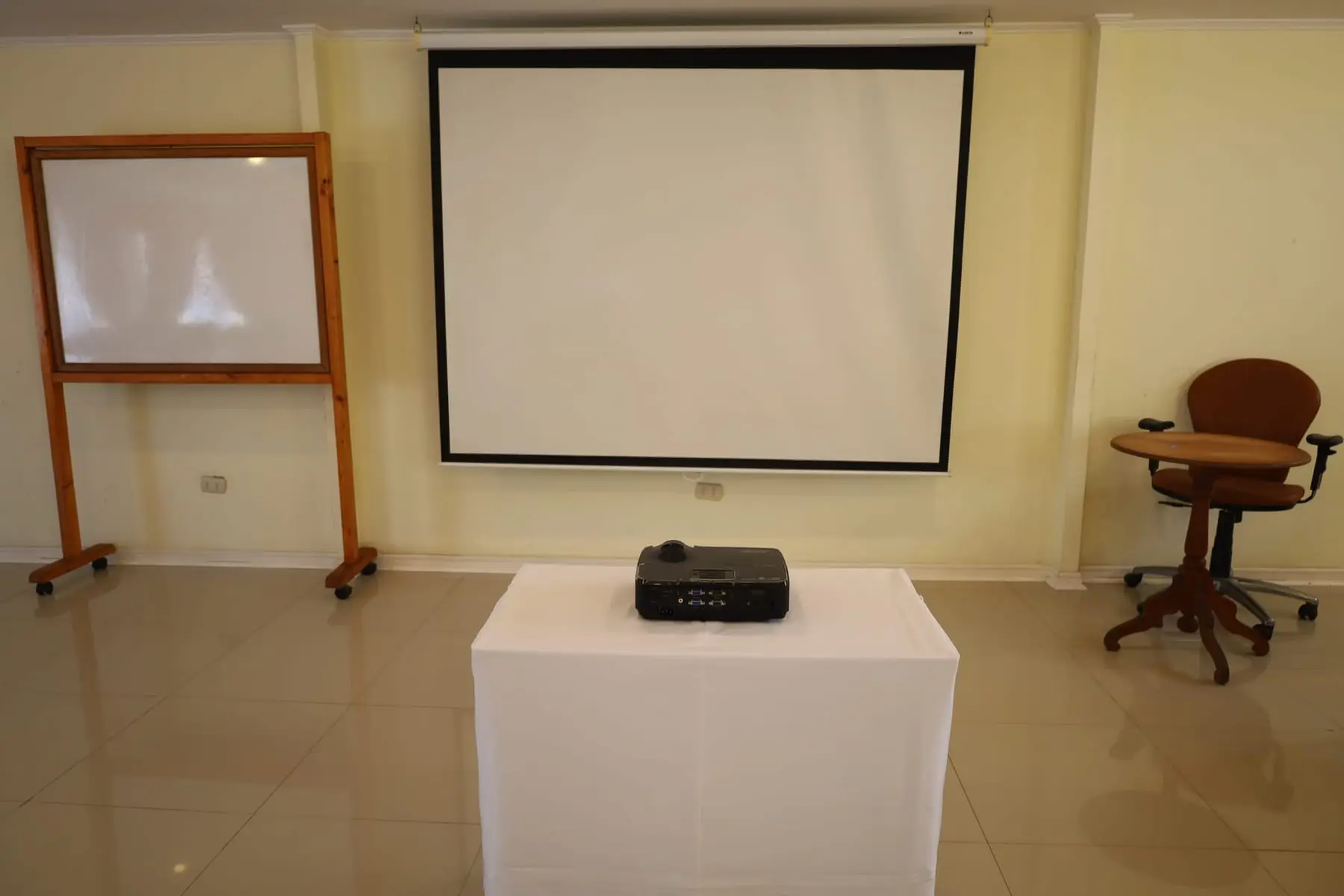 Proyector, telón y pizarra de la sala de reuniones