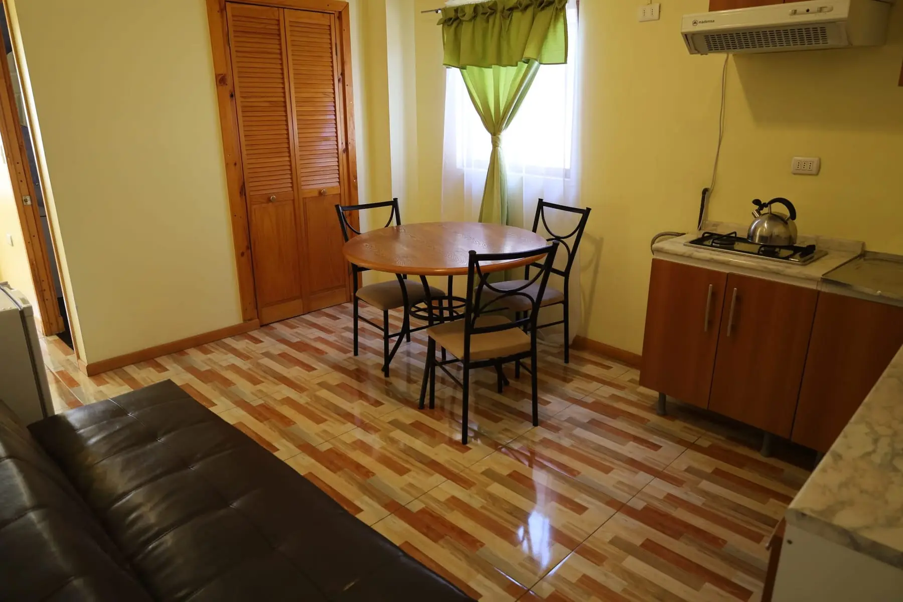 Living comedor con sofá cama, mesa redonda y cocina