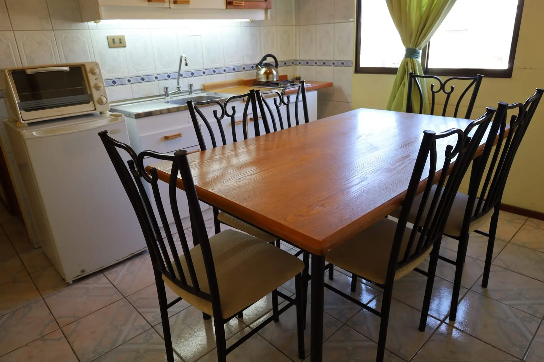 Comedor con mesa de madera y cocina equipada
