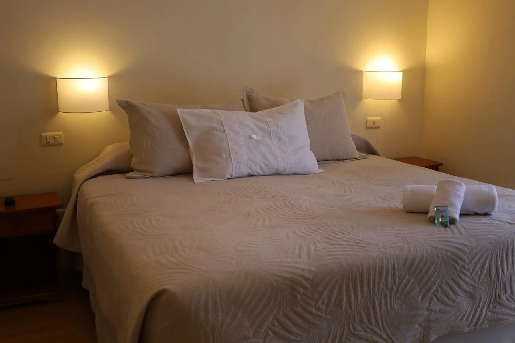 Cama matrimonial con lámparas de muro