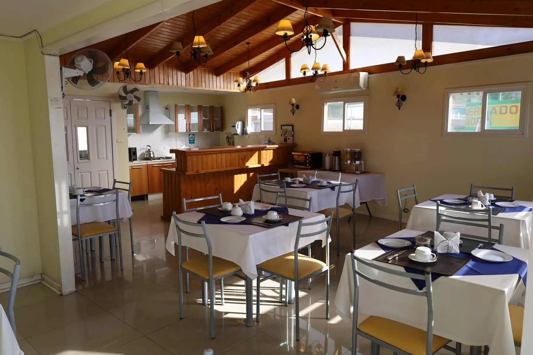 Comedor de desayuno con techo de madera y mesas preparadas
