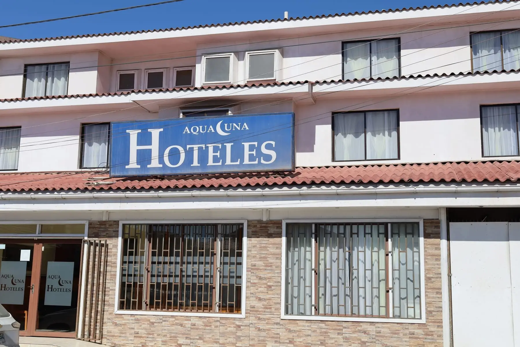 Fachada de Aqualuna Salida Norte, edificio blanco de tres pisos con letrero azul